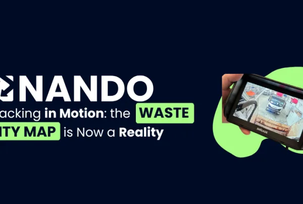 Image with a blue background, on the left the white NANDO logo and the title 'Tracking in motion: the Waste City Map is now a reality'. On the right, a monitor displays a truck in real-time while performing waste collection.